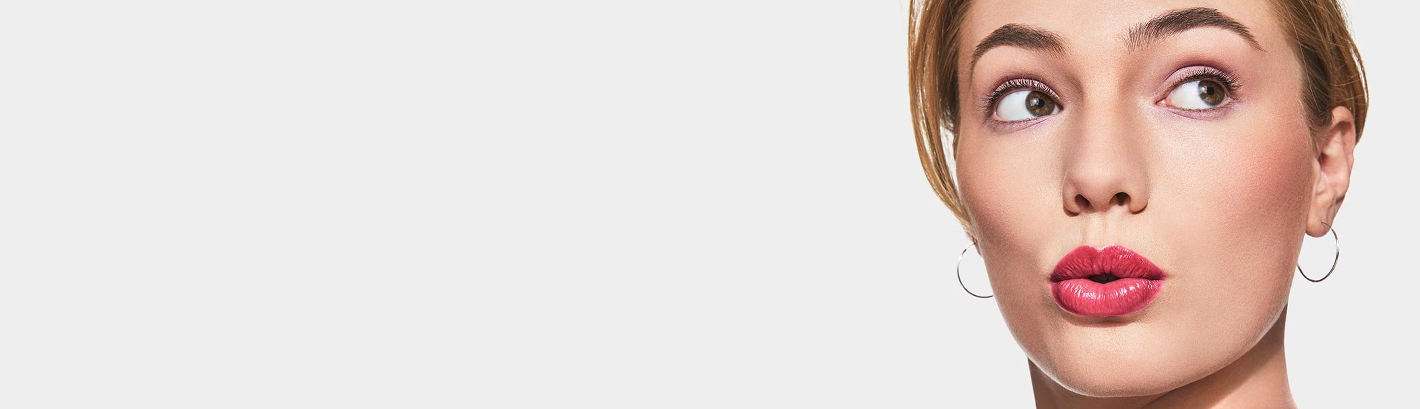 Close up of blonde model wearing a selection of bestselling Clinique makeup products, in a brightly lit studio