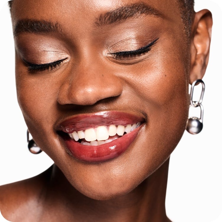 Selection of new brow and eye products dynamically placed on a glass shelf, in a brightly lit studio setting