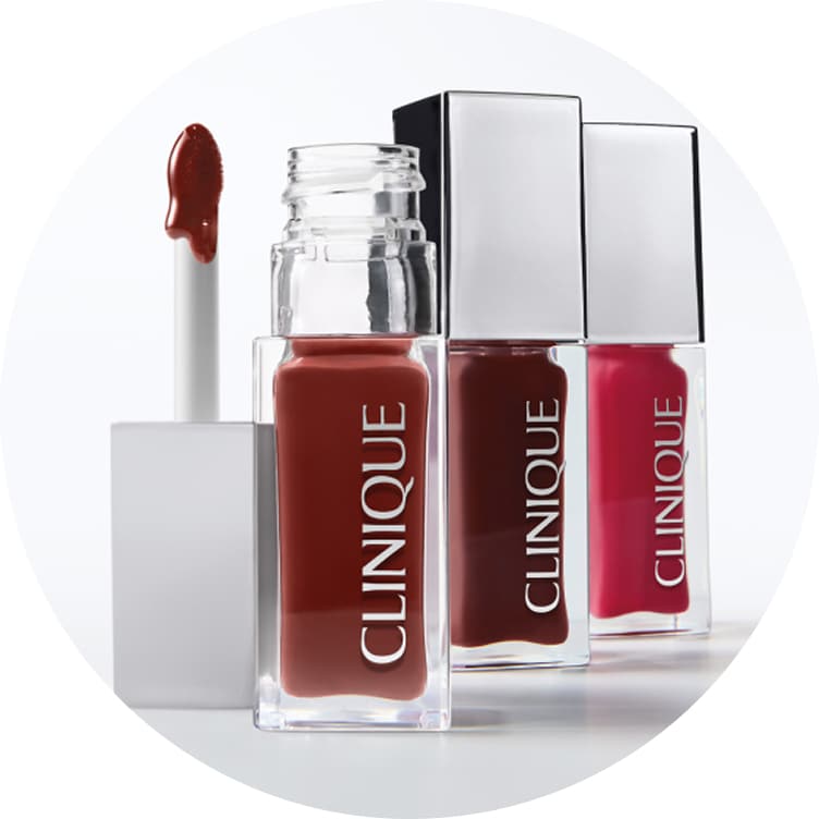 Clinique Lip + Cheek Oil bottles displayed upright with a tinted formula and applicator.