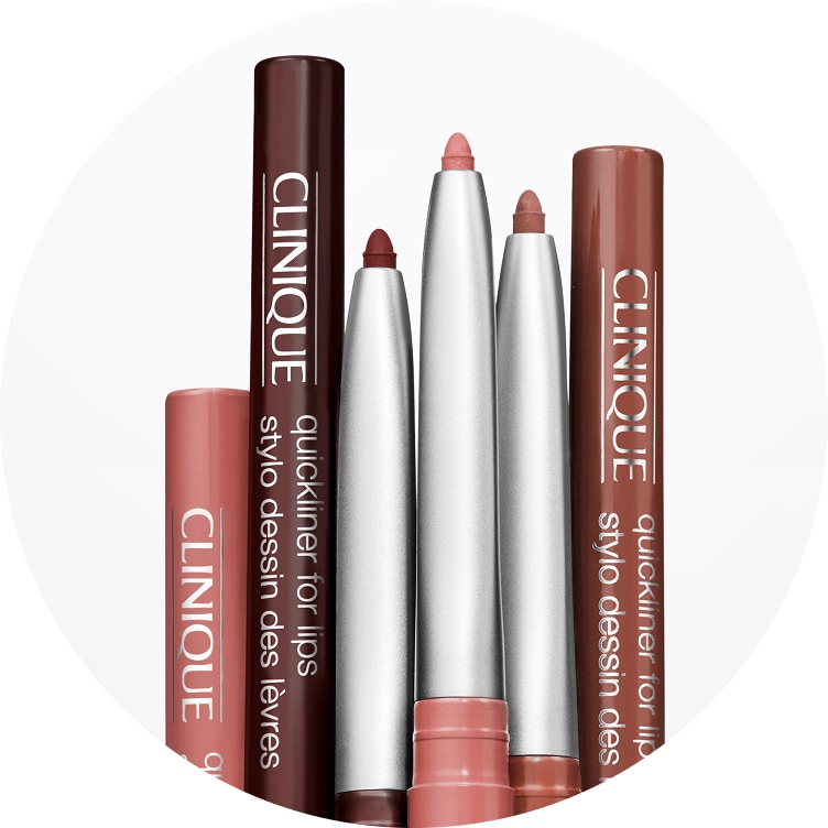 A lineup of Clinique lip liners in various shades shown uncapped with sharpened tips.
