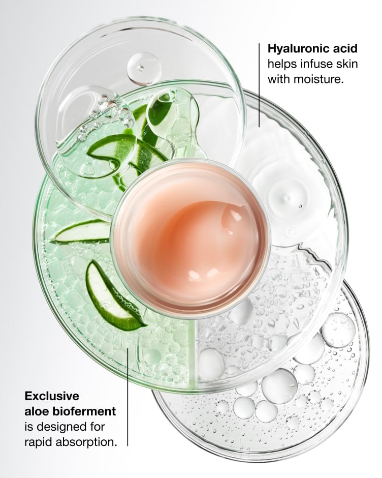 Close up of Moisture Surge Moisturiser, shot from above, in front of ingredients on lab glass petri dishes