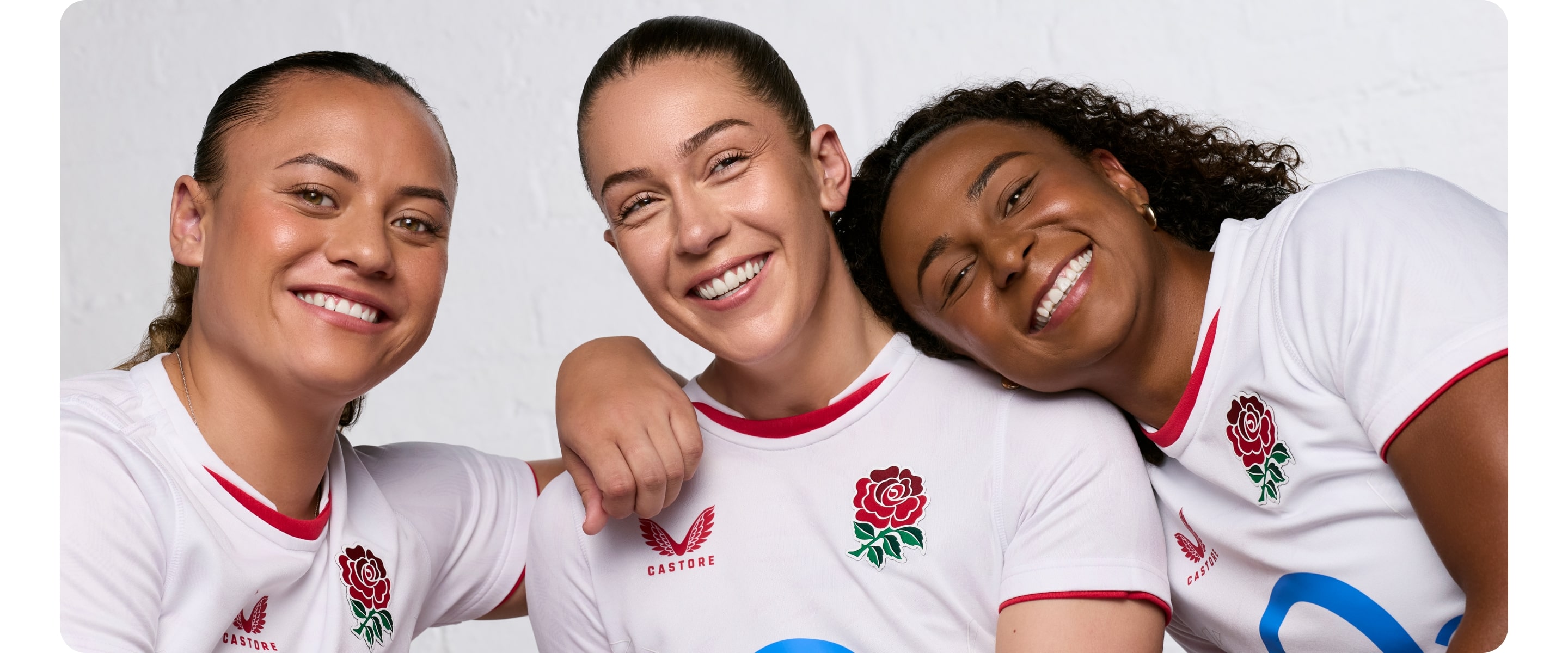 Close up of Holly Aitchison, Jade Shekells and Maddie Feaunati, smiling together with arms around each other