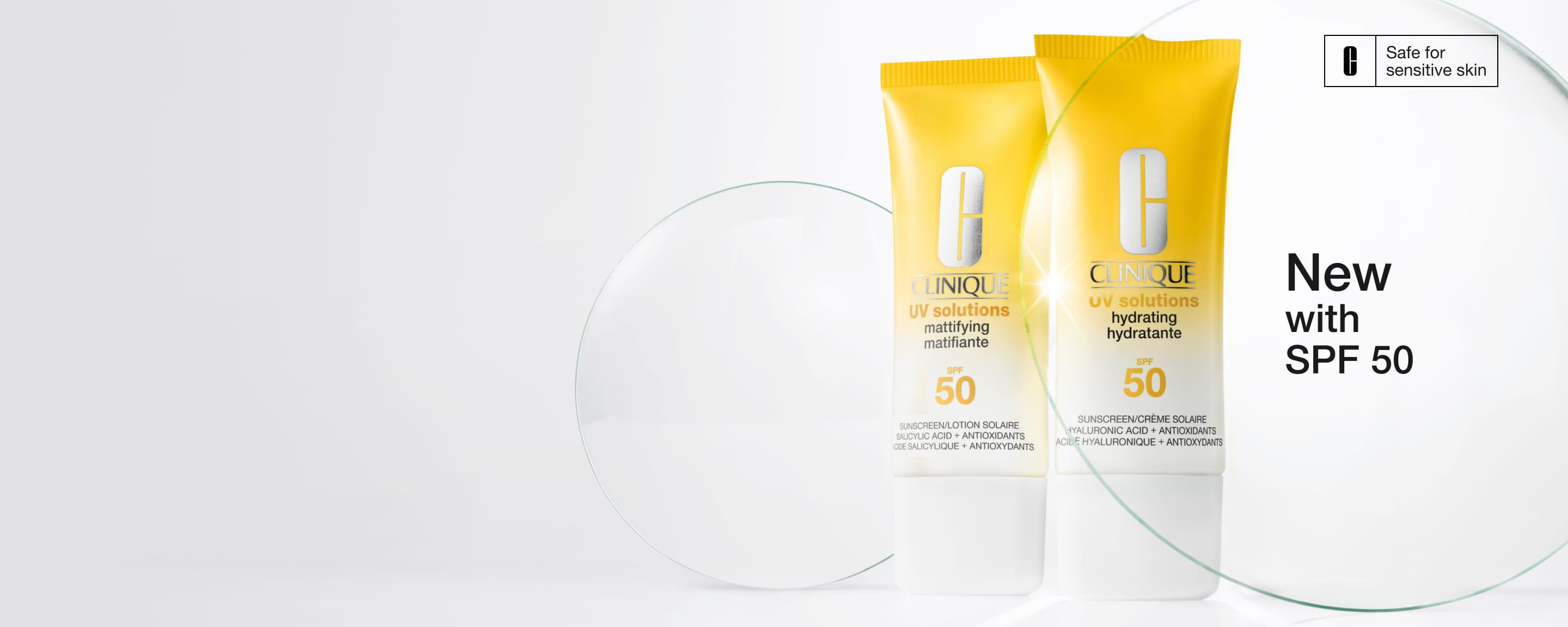 New Clinique UV Solutions Sunscreen SPF 50 in a brightly lit setting, next to glass discs in a brightly lit setting