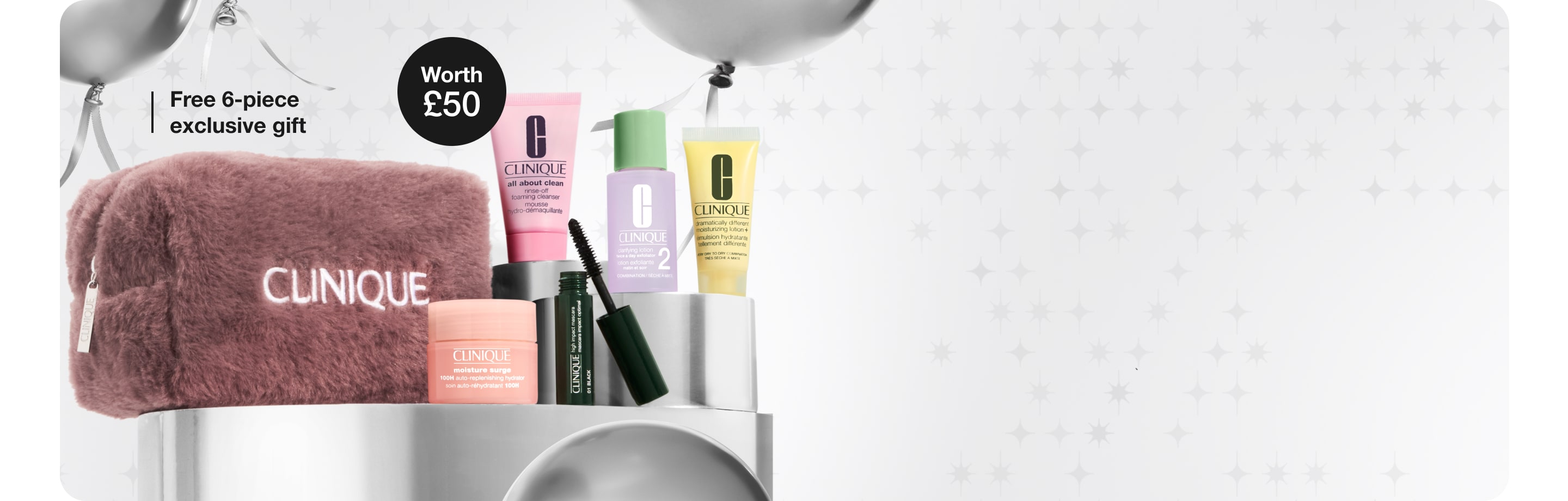 5 Clinique minis and a nude honey inspired makeup bag on a grey plinth, surrounded by silver balloons