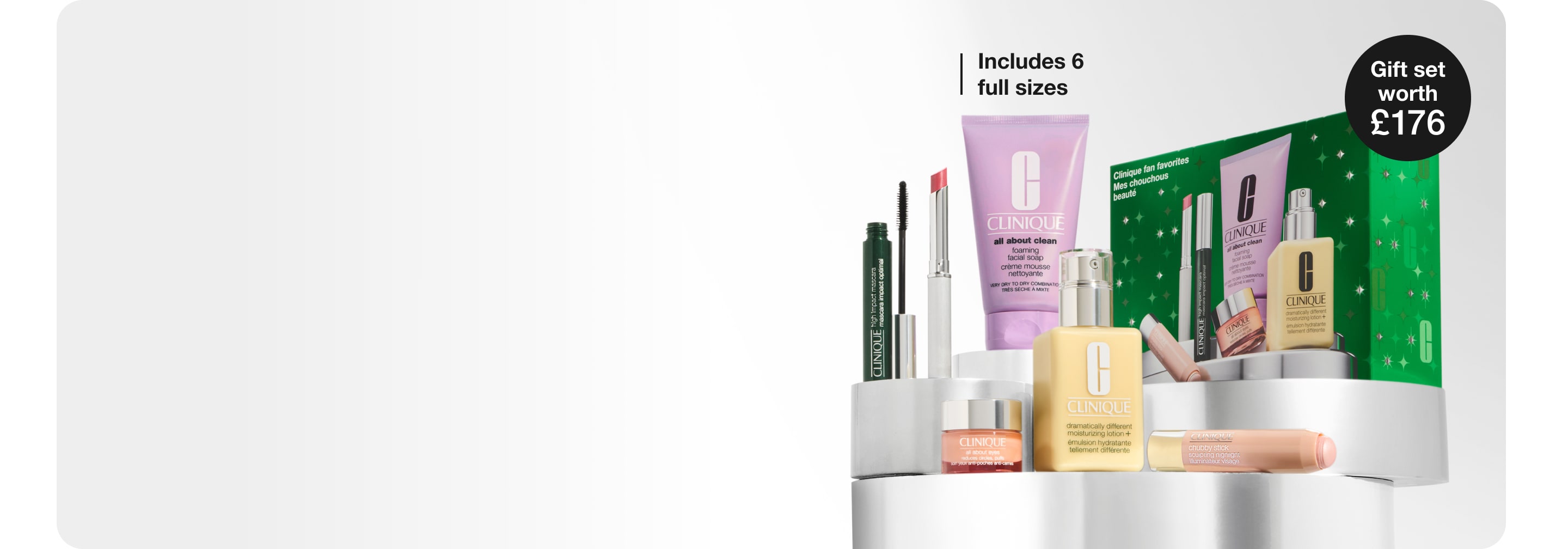 5 Clinique minis and a nude honey inspired makeup bag on a grey plinth, surrounded by silver balloons